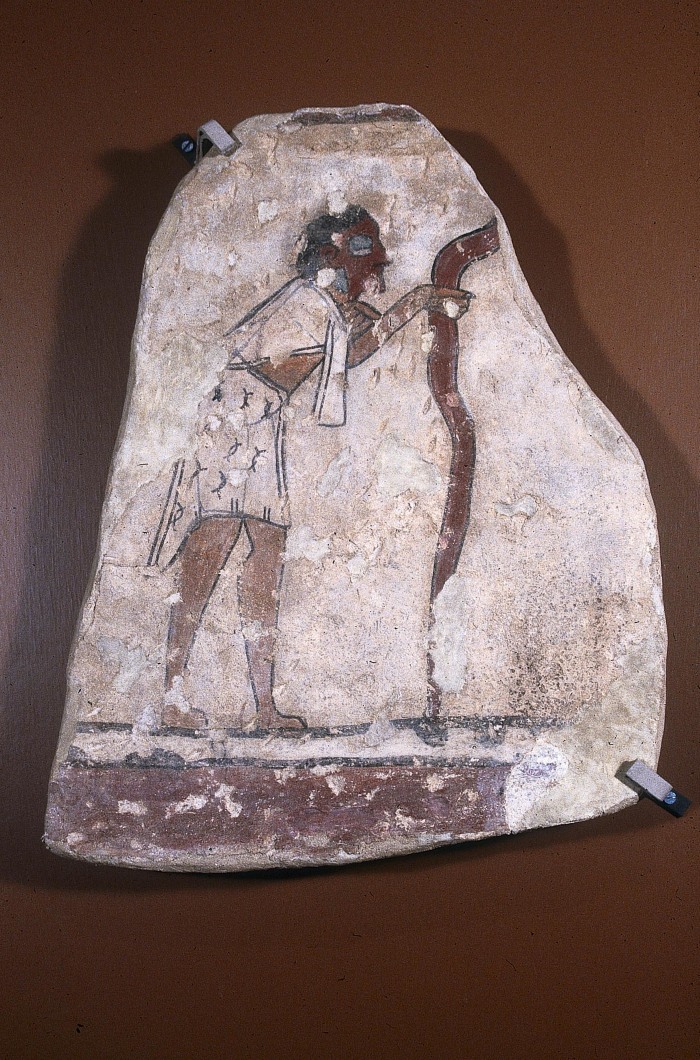 FRAGMENTO DE MURAL CON PERSONAJE ENMASCARADO Y COA
