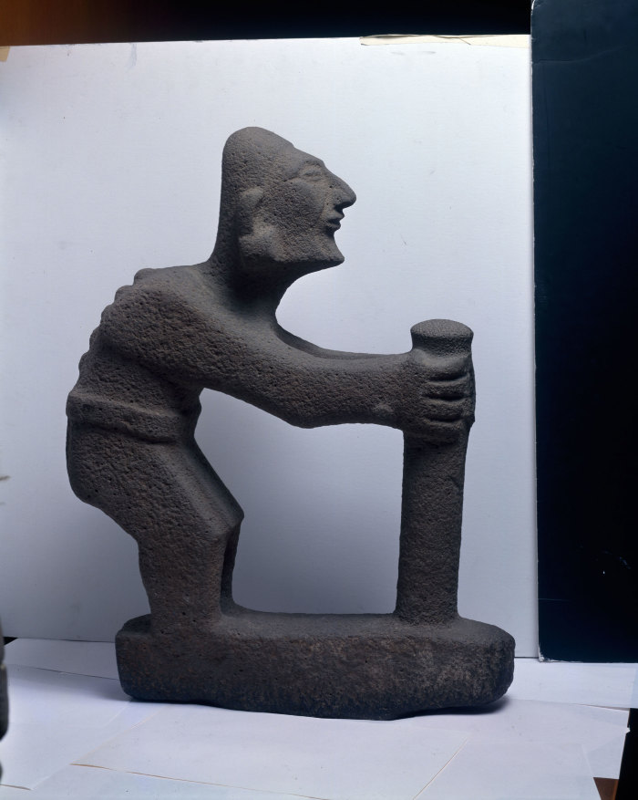 Escultura de un personaje encorvado con bastón