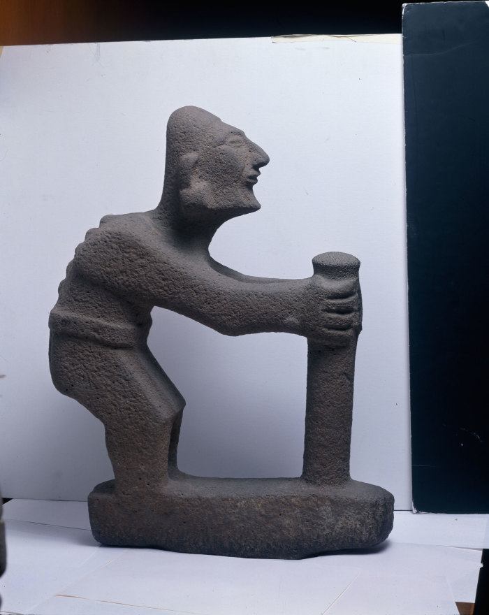 Escultura de un personaje encorvado con bastón