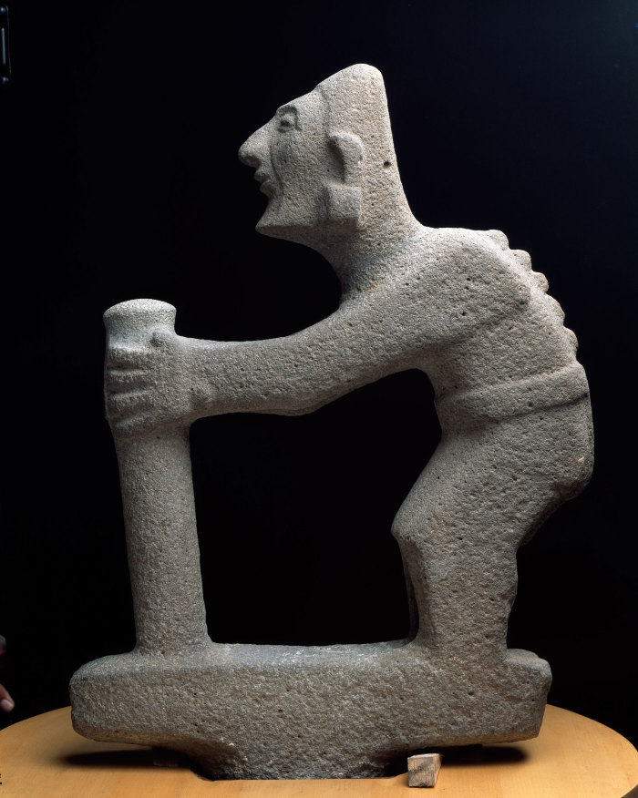 Escultura de un personaje encorvado con bastón