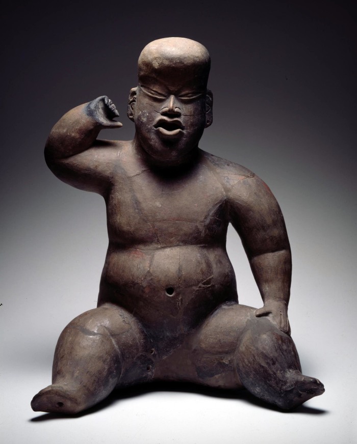 Figura hueca sentada con brazo levantado