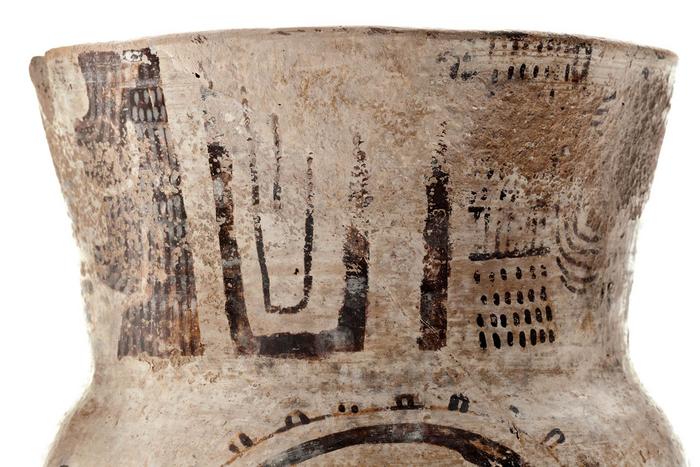 Detalle de vaso trípode negro sobre blanco 