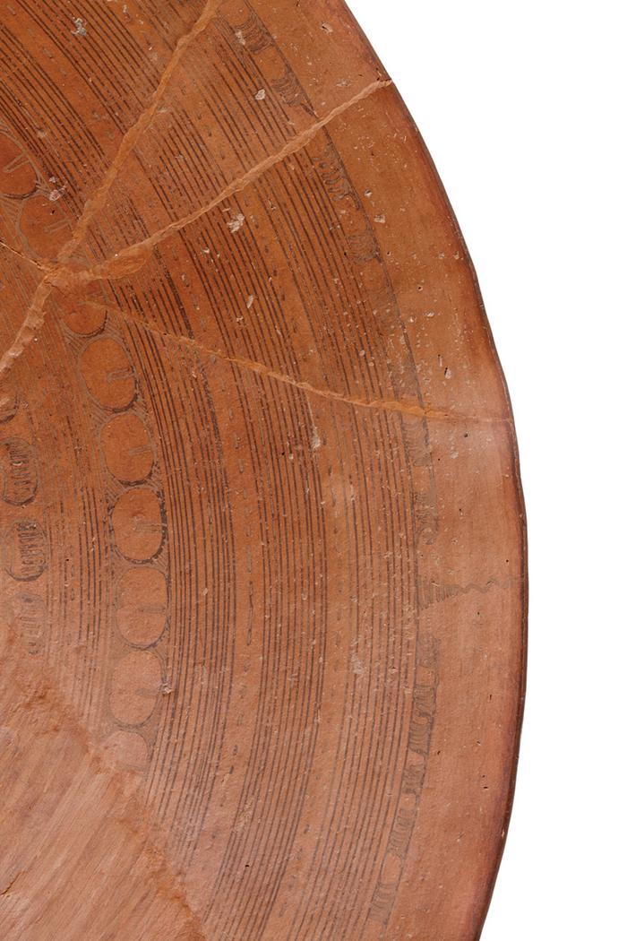 Detalle de plato con elementos simbólicos acuáticos y geométricos