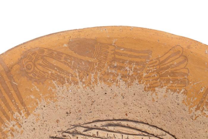 Detalle de molcajete trípode negro sobre anaranjado