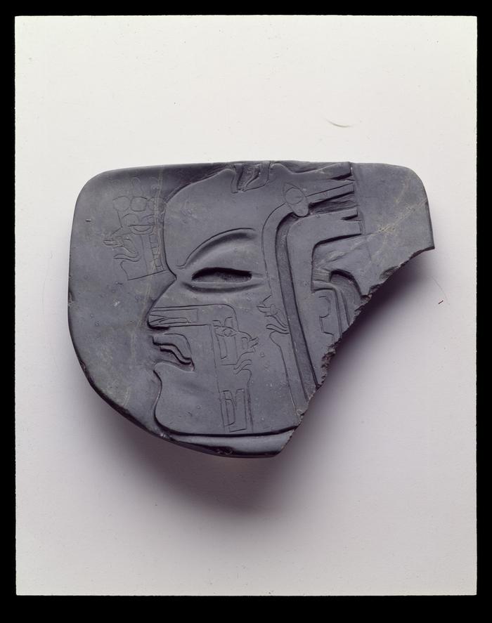 Placa rectangular con un rostro humano inciso